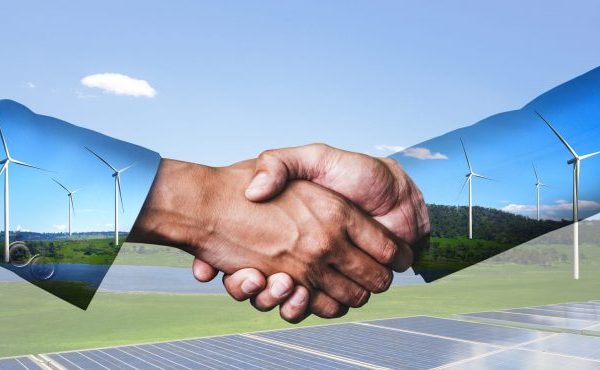 Double exposure graphic of business people handshake over wind turbine farm and green renewable energy worker interface. Concept of sustainability development by alternative energy.